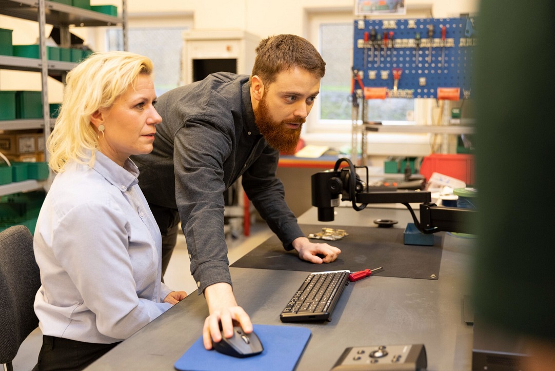 Microscope operators inspect sample together on a digital microscope