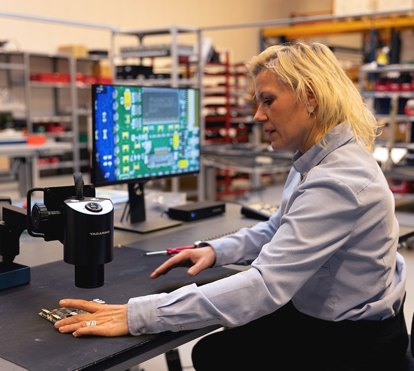 Employee inspects PCB under digital microscope