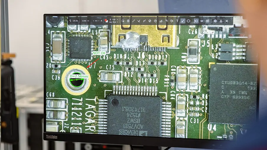 Over the shoulder shot of man using a TAGARNO digital microscope with Measurement software to do quality control of a magnified PCB