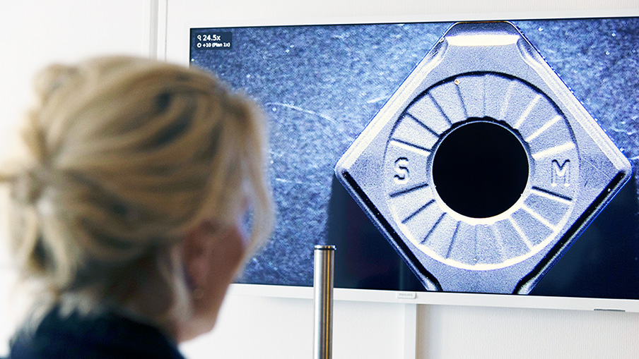 Over the shoulder shot of woman looking at a monitor with a magnified bolt