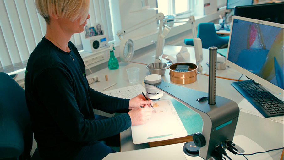 Woman using microscope with camera for inspecting seeds