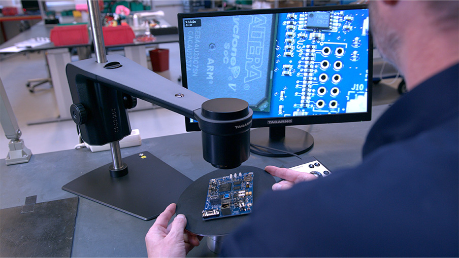 Man using a digital microscope to inspect a PCB